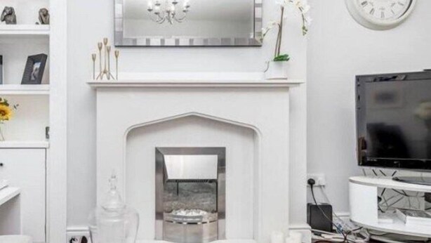 A modern living room with a white fireplace, a mounted TV, and a chandelier. - Balmoral Residence - 30 min to Glasgow & Edinburgh (Falkirk)
