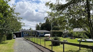 A residential area with a gravel driveway leading to a blue house with a number 17. - 4 Star Holiday Home in Hillerod (Hillerod)