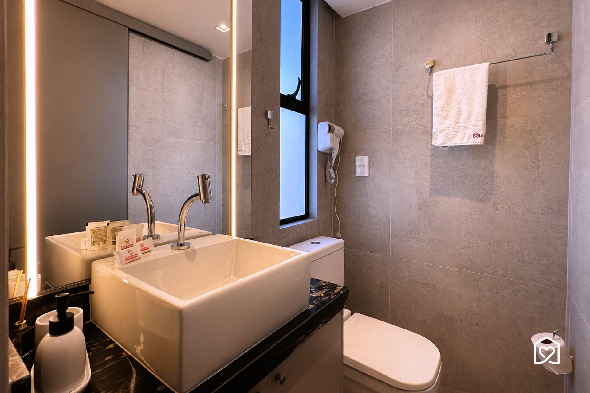 A modern bathroom with a large sink, a toilet, and a mirror.