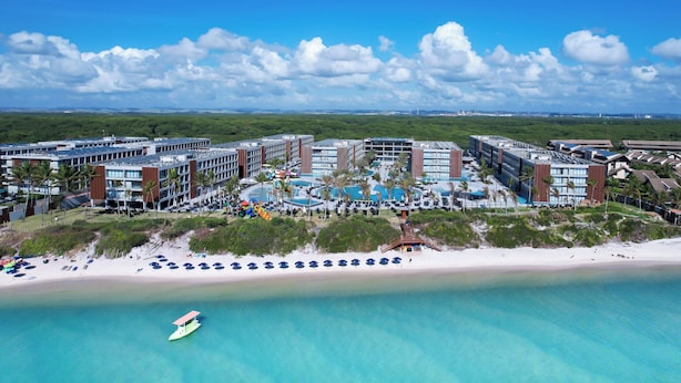 A resort with multiple buildings, a beach, and a pool area. - Porto 2 Life Resorts (Ipojuca)