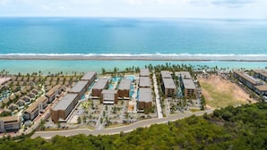 An aerial view of a resort with multiple buildings, a swimming pool, and a beach. - Porto 2 Life Resorts (Ipojuca)