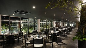 A spacious indoor dining area with multiple tables and chairs, large windows, and indoor plants. - Porto 2 Life Resorts (Ipojuca)