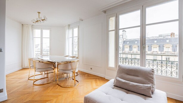 A spacious room with a dining table and chairs, large windows with a view of buildings, and a sofa. - Two bedroom  in France, Paris (Paris)