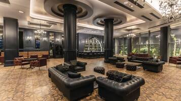 Un hall espacioso con sofás de cuero, una zona de bar y amplias ventanas.