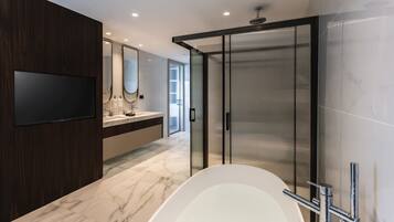 Un bagno moderno con una vasca da bagno ampia, uno specchio e un box doccia.
