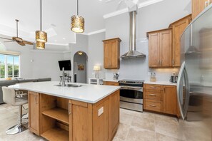 A modern kitchen with wooden cabinets, stainless steel appliances, and a large island. - Private - Heated Pool Waterfront Home - Coastal Escape in Port Charlotte, FL. (Port Charlotte)