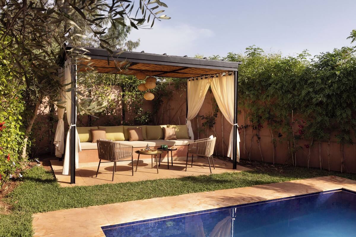 A covered outdoor seating area with a pool.