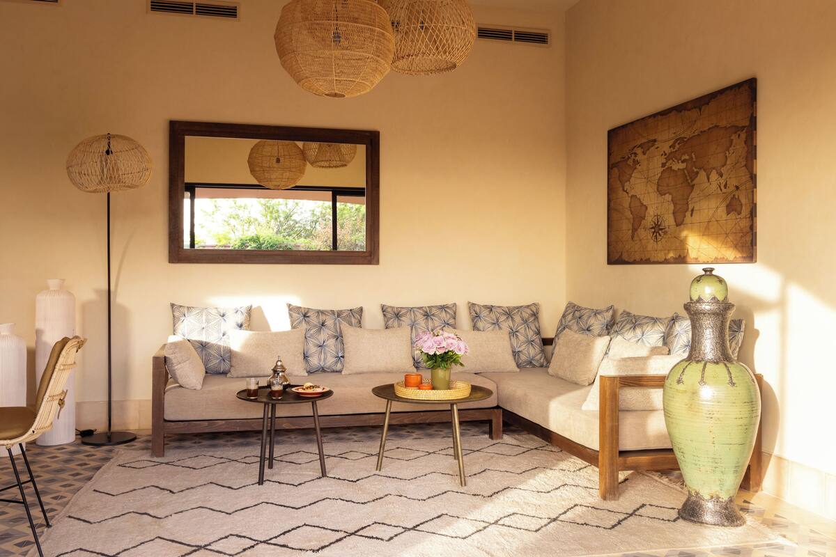 A living room with a sofa, a coffee table, a vase, and a world map on the wall.