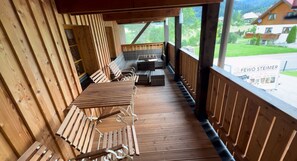 A wooden deck with outdoor seating and a view of a residential area.
