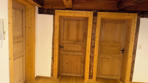 Um quarto com portas e teto de madeira.