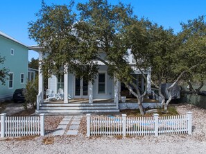 A two-story house with a porch, a white picket fence, and a driveway. - Sandy Toes on Parks Edge (Orange Beach)
