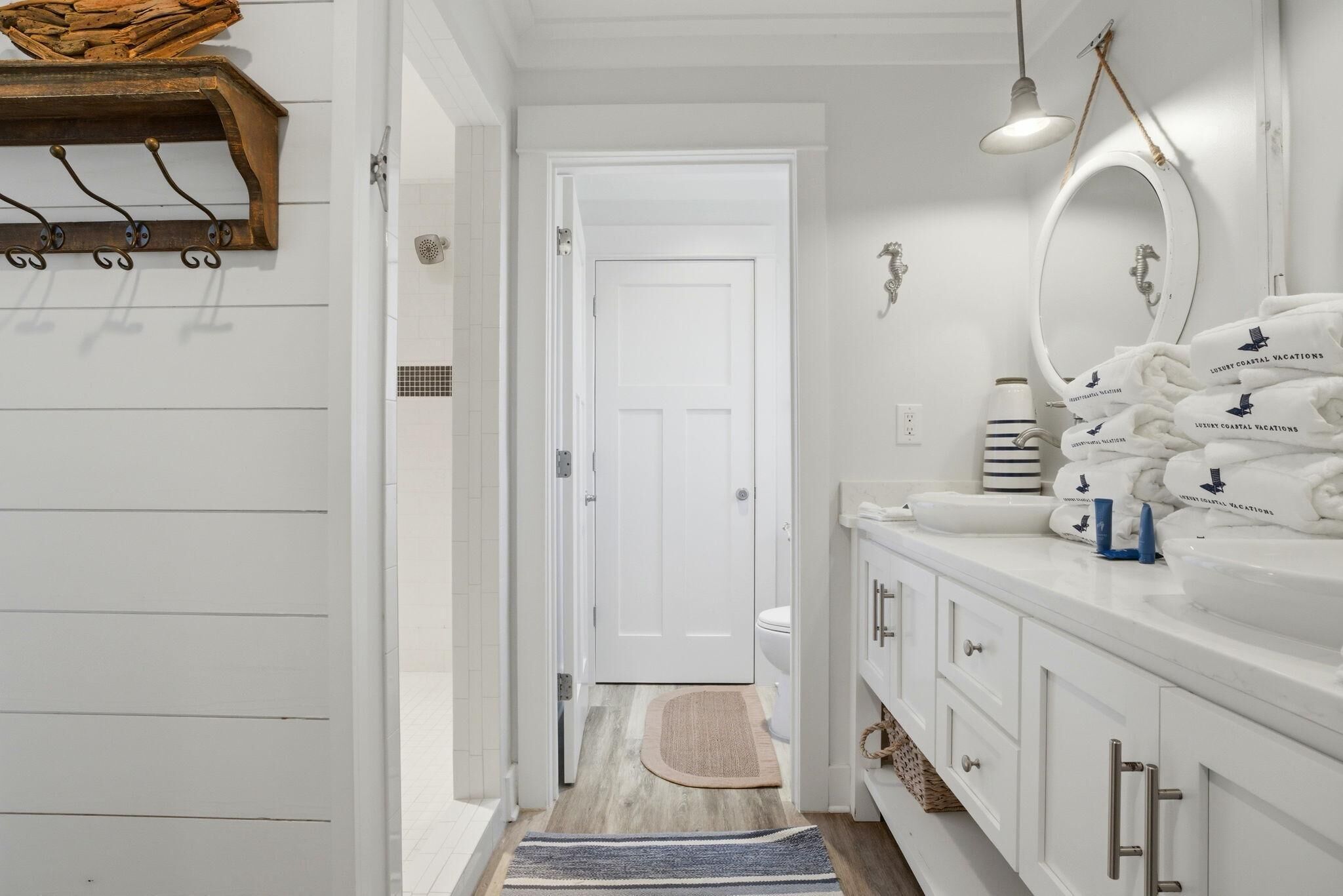 A bathroom with a white vanity, a mirror, and towels.