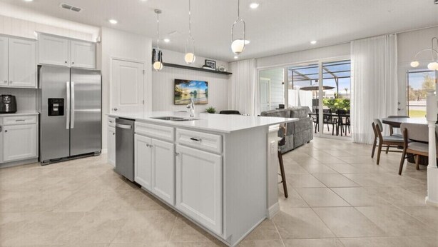 A modern kitchen with white cabinetry, stainless steel appliances, and pendant lighting. - Last Minute Disney Getaway! Luxury Townhouse with Private Pool. Book Now! #148203 (Orlando)