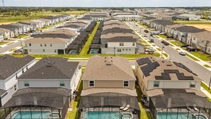 Een woonwijk met meerdere huizen, een zwembad en een overdekt buitengebied.
