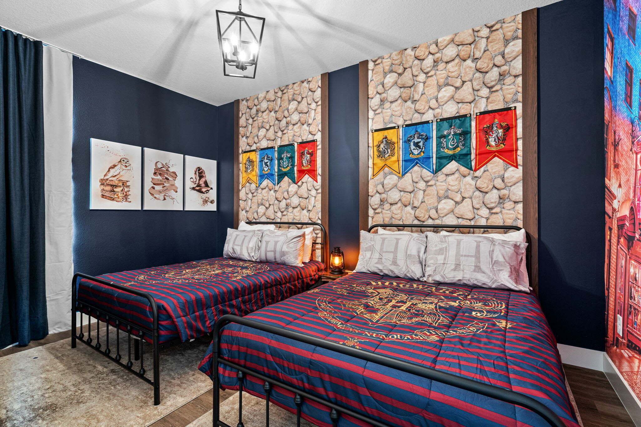 A room with two beds, a stone wall, and a series of flags.