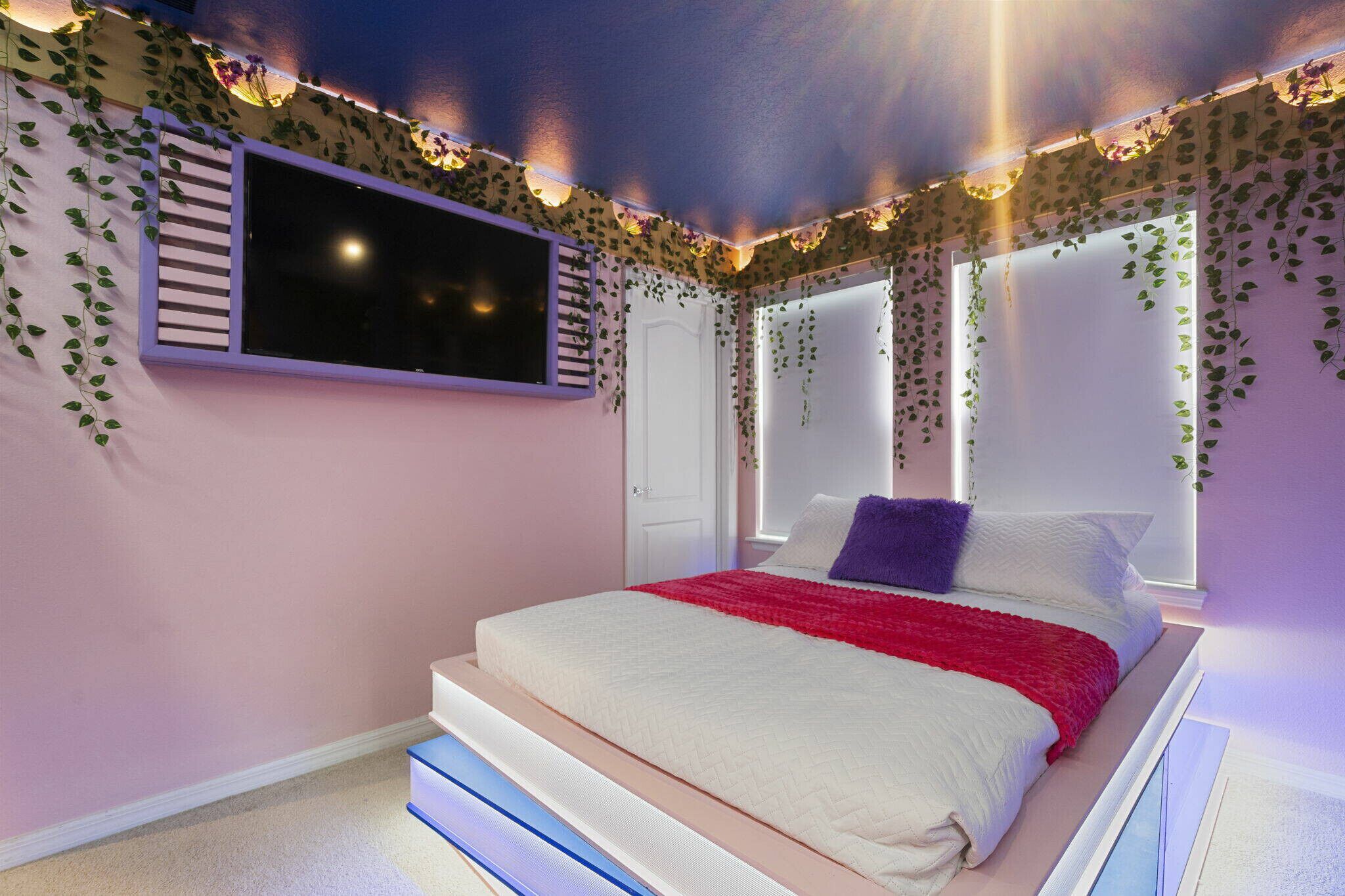 A bedroom with a bed, a window, and a door.