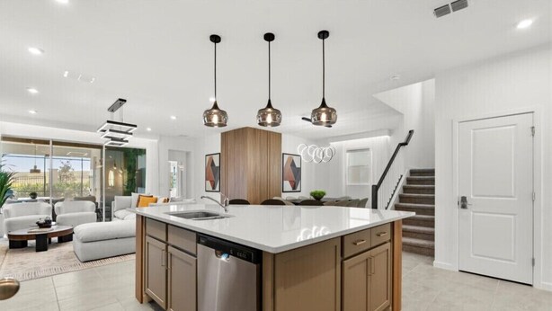 A modern kitchen with a central island, pendant lighting, and a dishwasher. - Last Minute Disney Getaway! Luxury Villa with Private Pool, Game Room & Themed Bedrooms. Book Now! #151423 (Orlando)