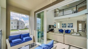 Un vaste espace de vie avec balcon, un ensemble de canapés et un coin repas.