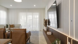 A modern living room with a sofa set, a coffee table, and a TV mounted on the wall. - Last Minute Disney Getaway! Luxury Villa with Private Pool, Game Room & Themed Bedrooms. Book Now! #152617 (Orlando)