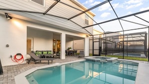 A swimming pool with a glass enclosure, outdoor seating, and a hot tub. - Last Minute Disney Getaway! Luxury Villa with Private Pool, Game Room & Themed Bedrooms. Book Now! #152617 (Orlando)