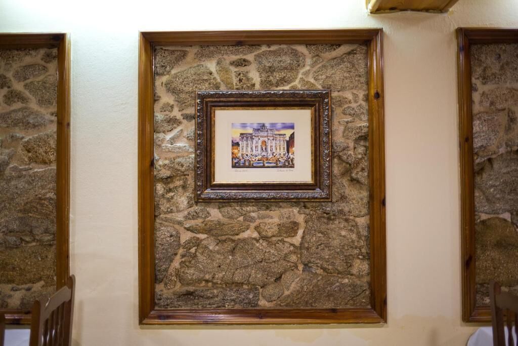 A framed picture on a stone wall.