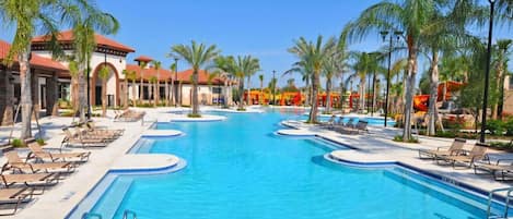A large swimming pool with lounge chairs and palm trees.