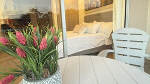 A balcony with a white table and a potted plant. - Cozy 1-bedroom apartment in charming Urb Don Jaca with AC (Urb Don Jaca)