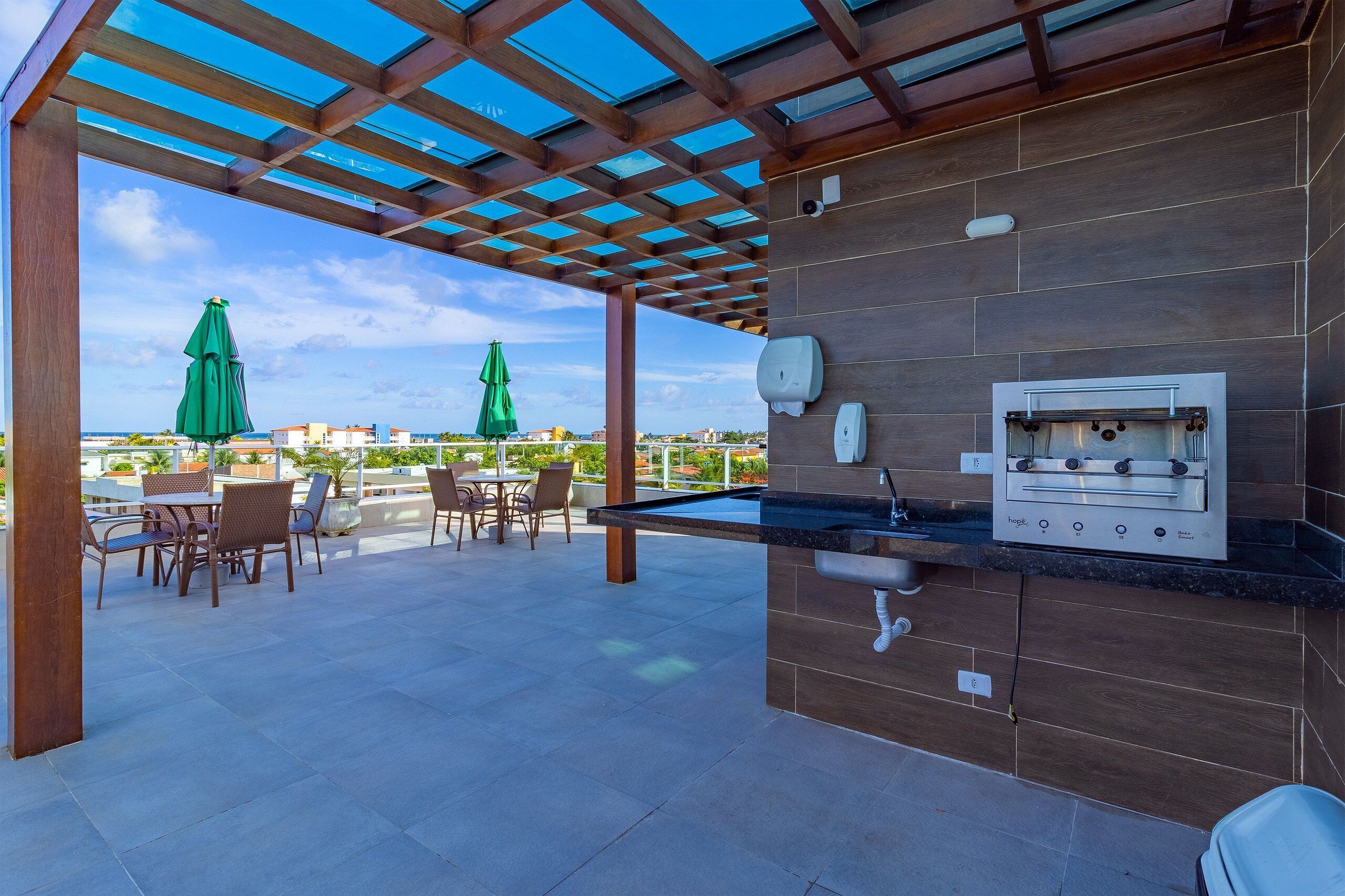 An outdoor patio with a pool table, seating, and a built-in grill.