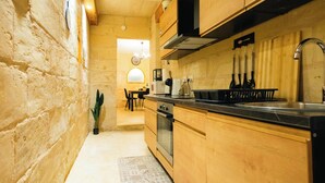 A kitchen with wooden cabinets, a black countertop, and a stainless steel sink. - Comfy 2 BR Flat in the Heart of Floriana (Floriana)