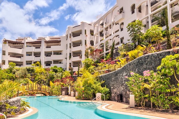 A resort with a swimming pool, multi-story buildings, and lush landscaping. - JARDINES - ISORA 0.3 GARDEN VIEW (Arona)