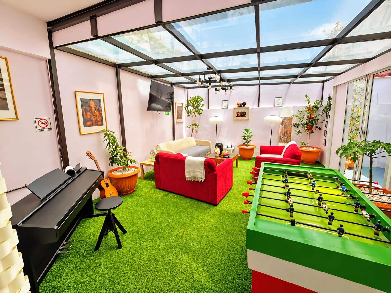 Un salon moderne avec un baby-foot, un piano et un canapé.