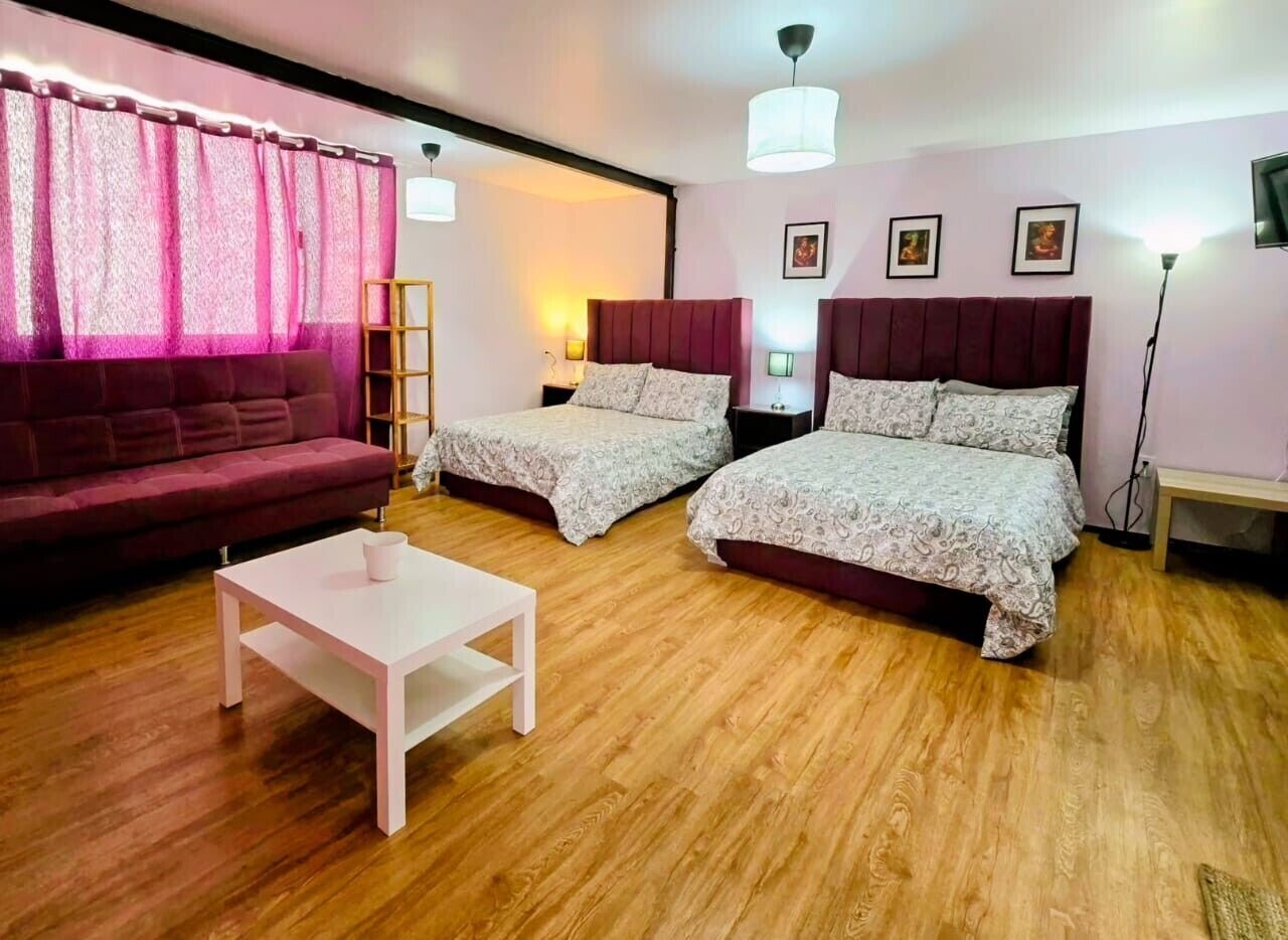 Ein Zimmer mit zwei Betten, einem Schlafsofa, einem Couchtisch und einem Fernseher.