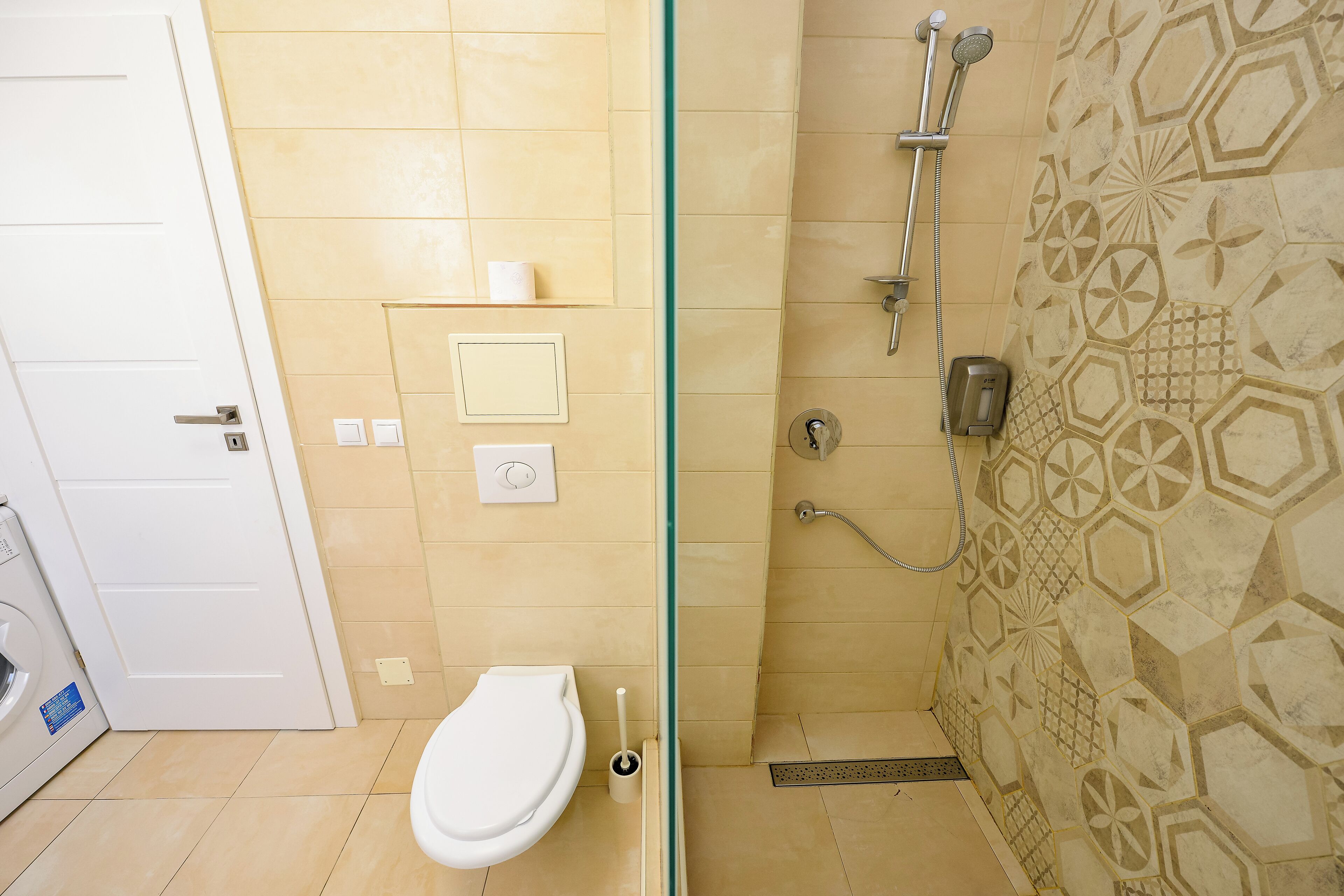 Une salle de bain équipée de toilettes, d’une douche et d’une paroi en verre.