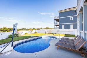 A swimming pool with lounge chairs and a basketball hoop in a backyard. - Ocean-view 4-bedroom, 3.5 bath Corrolla home w/pool+hot tub - sleeps 11 (Corolla)