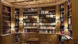 A library with wooden bookshelves, two chairs, and wall-mounted lamps. - Magnificent family home, 7 bedrooms, 13 beds, 5' zoo Beauval (Seigy)