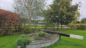 Een tuin met een verhoogd bloembed en een houten bank.