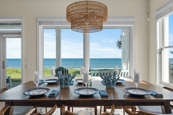 Bright ocean view dining space with floor-to-ceiling windows.