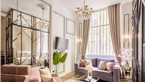 Een moderne woonkamer met een bank, salontafel en een aan de muur bevestigde televisie.
