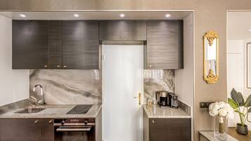 A modern kitchen with dark cabinets, a marble backsplash, and stainless steel appliances.