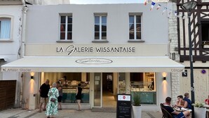 Ein Laden namens „LA GALERIE WISSANTAISE“ mit einem Schild und einigen Personen davor.