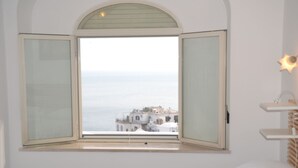 A bedroom with a large window, a bed, and a bedside table. - Spacious 5-bedroom in Positano center, on 2 floor,2 terraces overlooking the sea (Positano)