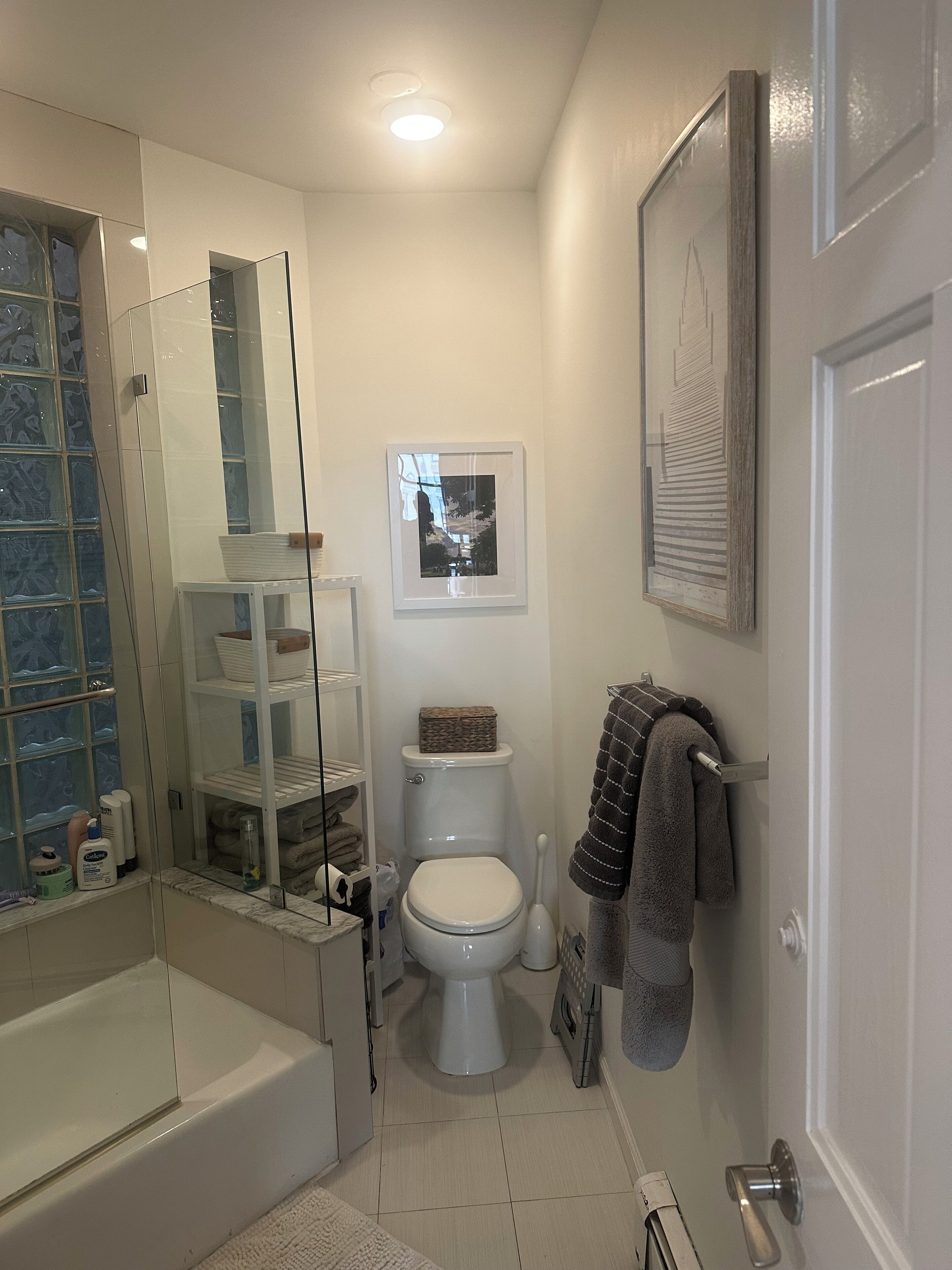 A bathroom with a bathtub, toilet, and glass shower enclosure.