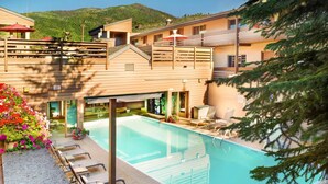 A hotel with a pool, outdoor seating, and a mountain view. - Family friendly 2-bedroom condo in Vail perfect for your year-round getaway (Vail)