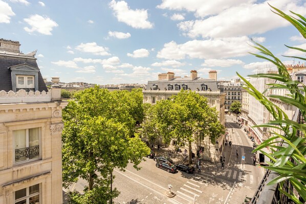 Une vue de rue avec des bâtiments, des arbres et des voitures.