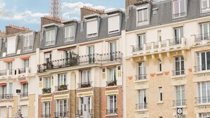 A row of terraced houses with a tower in the background. - Signature Suite Eiffel Tower terrace (Paris)