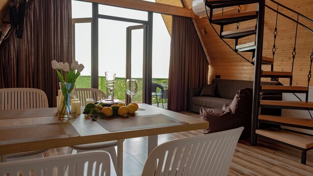 Un interior moderno con comedor, sofá y escalera de caracol.