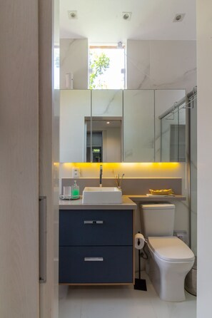 A modern bathroom with a white sink, dark cabinet, and a toilet. - Apartment on Gigoia Island Gigoia Class (Rio de Janeiro)