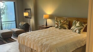 A bedroom with a large bed, a chair, a nightstand, and a lamp. - Waterfront, Direct View/Access, 2/2 TownHome, Grnd Level w Dock in Key Largo, FL (Key Largo)
