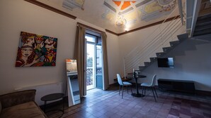 Ein modernes Interieur mit einer Treppe, einem Essbereich und einem farbenfrohen Gemälde an der Wand.