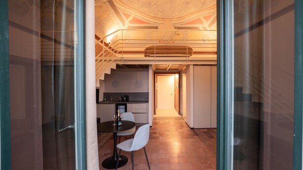 Ein modernes Interieur mit Essbereich, einer Küche und einem Flur, der zu einer Tür führt.